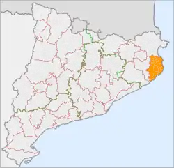 Map of Catalonia, with Baix Emporda shown in solid orange. Comarca boundaries are shown in red, with provincial boundaries in green.