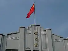 Picture of Longmen Building and Chinese Flag.