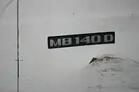 Badge on vehicle, reading "MB140D"