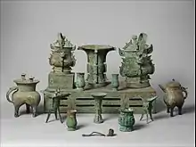 Altar set; late 11th century BC; bronze; overall (table): height: 18.1&nbsp;cm (7.mw-parser-output .frac{white-space:nowrap}.mw-parser-output .frac .num,.mw-parser-output .frac .den{font-size:80%;line-height:0;vertical-align:super}.mw-parser-output .frac .den{vertical-align:sub}.mw-parser-output .sr-only{border:0;clip:rect(0,0,0,0);clip-path:polygon(0px 0px,0px 0px,0px 0px);height:1px;margin:-1px;overflow:hidden;padding:0;position:absolute;width:1px}1⁄8 in.), width: 46.4&nbsp;cm (18.mw-parser-output .frac{white-space:nowrap}.mw-parser-output .frac .num,.mw-parser-output .frac .den{font-size:80%;line-height:0;vertical-align:super}.mw-parser-output .frac .den{vertical-align:sub}.mw-parser-output .sr-only{border:0;clip:rect(0,0,0,0);clip-path:polygon(0px 0px,0px 0px,0px 0px);height:1px;margin:-1px;overflow:hidden;padding:0;position:absolute;width:1px}1⁄4 in.), depth: 89.9&nbsp;cm (35.mw-parser-output .frac{white-space:nowrap}.mw-parser-output .frac .num,.mw-parser-output .frac .den{font-size:80%;line-height:0;vertical-align:super}.mw-parser-output .frac .den{vertical-align:sub}.mw-parser-output .sr-only{border:0;clip:rect(0,0,0,0);clip-path:polygon(0px 0px,0px 0px,0px 0px);height:1px;margin:-1px;overflow:hidden;padding:0;position:absolute;width:1px}3⁄8 in.); Metropolitan Museum of Art (New York City, U.S.)