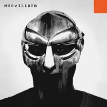 Grayscale photo of Doom's face behind his metal mask, with word "MADVILLAIN" in pixelated black font at the top left corner and small orange square at the top right corner.