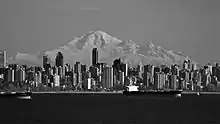 Black and white picture of the downtown Vancouver cityscape, a mountain in seen in the background.