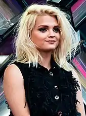 Smiling blonde woman in a sleeveless black top.