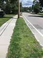 A curb strip in suburban Greater Boston, Massachusetts. Outside of rural areas in New England, devil strips are narrow – the one pictured is 52 inches (130&nbsp;cm; 1.3&nbsp;m) from curb to sidewalk.  They are usually not maintained by the municipality, but rather by the property owner, and are used primarily to provide space for utility poles.