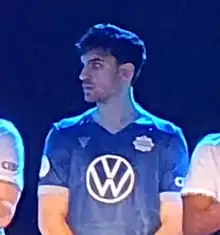 Man standing up on stage looking to the left