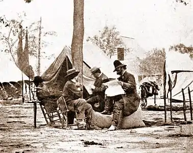 Brady (center, wearing straw hat), with General Ambrose Burnside (reading newspaper), taken in May 1864 (See Frassanito "Grant and Lee The Virginia Campaigns")