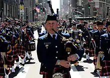 An auxiliarist piper in highland dress uniform performing as part of the Coast Guard Pipe Band. The Coast Guard Pipe Band is composed of active duty, reservists and retired members of the U.S. Coast Guard and members of the U.S Coast Guard Auxiliary.