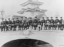 B&W photo of men sitting on a bridge