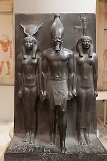 Goddess representation in Egyptian monuments: in this triad the Egyptian goddess Hathor (left) and the nome goddess Bat (right) lead Pharaoh Menkaura (middle). Egypt, Fourth dynasty, about 2400 BCE. Graywacke. Cairo Museum.