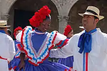 A man and woman in colorful dress dancing