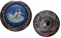 Wedgwood button with Boulton cut steels, depicting a mermaid & family, England, c. 1760. Diameter just over 32 mm (1.mw-parser-output .frac{white-space:nowrap}.mw-parser-output .frac .num,.mw-parser-output .frac .den{font-size:80%;line-height:0;vertical-align:super}.mw-parser-output .frac .den{vertical-align:sub}.mw-parser-output .sr-only{border:0;clip:rect(0,0,0,0);clip-path:polygon(0px 0px,0px 0px,0px 0px);height:1px;margin:-1px;overflow:hidden;padding:0;position:absolute;width:1px}1⁄4")