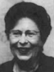 An older white woman, with dark hair, wearing glasses.