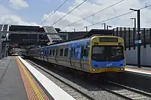 A train arriving at Sunshine station, showing the accessible tactile boarding indicators on the platforms