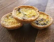 Three small individual quiches with mushrooms and pale custard filling