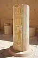 The lower section of a column, still standing, with many hieroglyphs and the painting of an individual