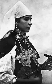 Image 18A Berber musician wearing two large triangular brooches in southern Morocco at the beginning of the 20th century (from Culture of Morocco)
