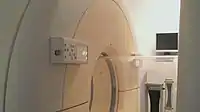 The circular containment tube separates the patient table in the "hot" zone (pathogen present) from the "cold" zone around this MRI machine