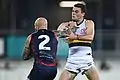 Nathan Jones applies a fend to the collar of Brad Crouch during an Australian rules game.