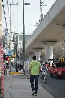 Photograph of a concrete bridge above an avenue