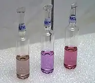 Neodymium compounds in fluorescent tube light—from left to right, the sulfate, nitrate, and chloride