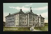 Architect's sketch of General Hopsital 3, a four-story building with balconies covering one face and an arched entrance at the end of the driveway..