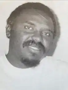 Black and white photo of Ngugi wa Mirii smiling