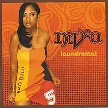 The single's cover, with Nivea wearing a wearing a yellow, orange, black, and red dress while standing against an orange background.