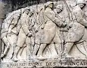 The relief on the Noyon war memorial commemorating the re-entry of the 13th Army Corps on 18 March 1917