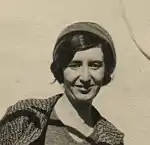 Black-and-white photograph of a woman cataloguing pottery in approximately 1958