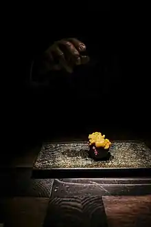 Chef’s hand leaving after placing a piece of Sushi (Sea Urchin) on your table