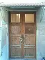 Wooden door entrance to first floor decorated with magen david and the word Zion in Hebrew.