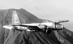 Plane in flight, with a mountain in the background