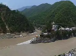 Confluence of Alaknanda (bottom, from right) and Mandakini River (flowing from top - North) at Rudraprayag. Before 17 June 2013, there was a footbridge (jhula) over the Mandakini; this was washed away in the 2013 Uttarakhand floods. The stones at the bottom of the stairs were not there; instead, there was a viewing platform, and a large rock called Narad Shila.