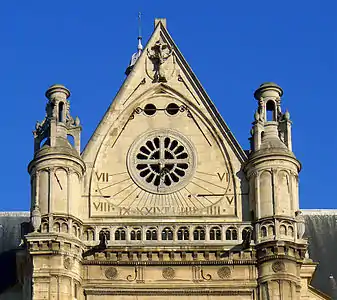 Detail of the south transept and sundial, with sculpture of deer with crucifix at top