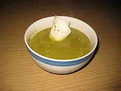 A thick pea soup garnished with a tortilla accent