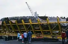 People standing in front of the wreck of the Mary Rose while in its protective cage
