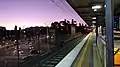 Westbound view from Platform 1 in January 2021. The junction of Punt Road and Olympic Boulevard is to the left, with AMMI Park in the distance.