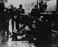 Police officers and fire fighters check for signs of life and collect personal items from victims of the Triangle fire.