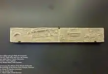 Photograph of a Roman marble sculpture, showing buildings shaking and being destroyed in an earthquake.