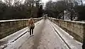 A pedestrian crosses Prebends Bridge in winter