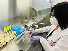 Photograph of a biologist holding a measurement equipment to a glass container