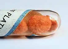 Photograph of an orange, powdery sample of platinum(II) chloride