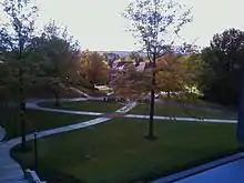 Picture of a campus quadrangle with pathways intersecting and a building in the distance
