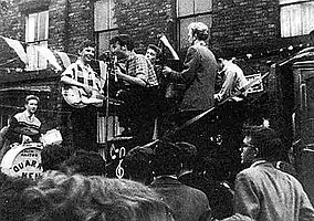 The Quarrymen performing in Rosebery Street, Liverpool on 22 June 1957 (Left to right: Hanton, Griffiths, Lennon, Garry, Shotton and Davis)