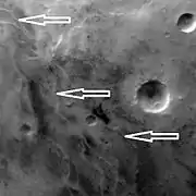 Ridges, believed to be eskers of the Dorsa Argentea Formation, as seen by Mars Global Surveyor wide angle MOC.  White arrows point to the ridges.