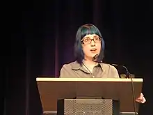 Watson speaking at a podium