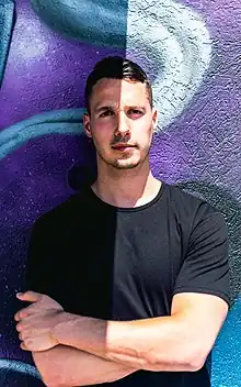 Reed Duchscher standing in front of a purple mural