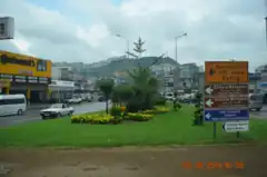 Photograph of an urban area. There are streets, road signs, and some green space.