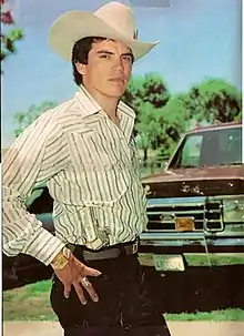 Chalino Sánchez poses with a holstered M1911 Infront of a truck