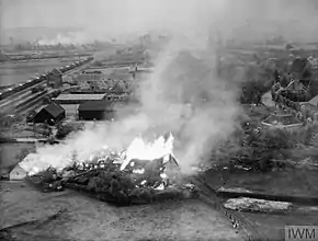 'Crocodile' flame throwing tanks were used against German positions to the East of s'Hertogenbosch. On the left of the picture is a German Red Cross train intact.